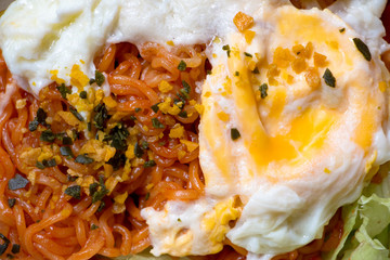 Close Up photo of cooked spicy sauce instant noodle topping with fried egg. The easy homemade dish can do it yourself.