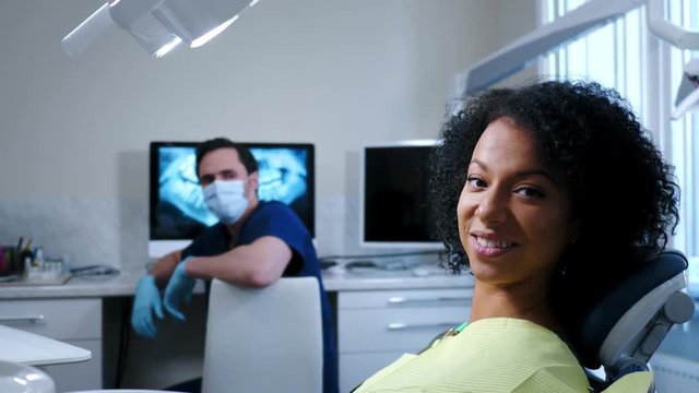 Man dentist showing x-ray results to his pacient.