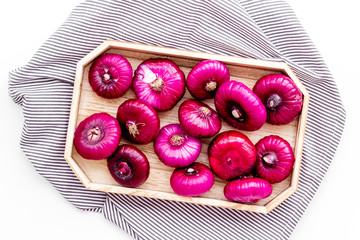 Red onion is healthy product. Onion bulbs in tray on white background top view