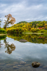 Reflection of a still river in Vermont during peak fall foliage season