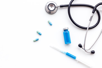 Medical examination and treatment concept. Stethoscope, syringe, pills on white background top view copy space