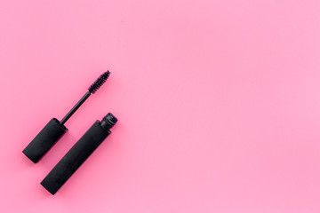 Mascara on pink background top view copy space