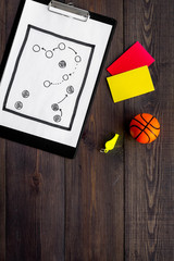 Sport judging concept. Basketball referee. Tactic plan for game, basketball ball, red and yellow cards, whistle on wooden background top view copy space