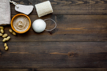 Naklejka na ściany i meble Treatment set with natural peanut scrub to take bath on wooden background top view mock-up