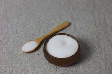 Salt in Cup made of wood with spoon  isolate on table
