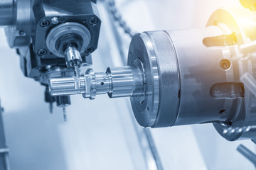 The  CNC lathe machine milling the steel shaft by milling spindle.