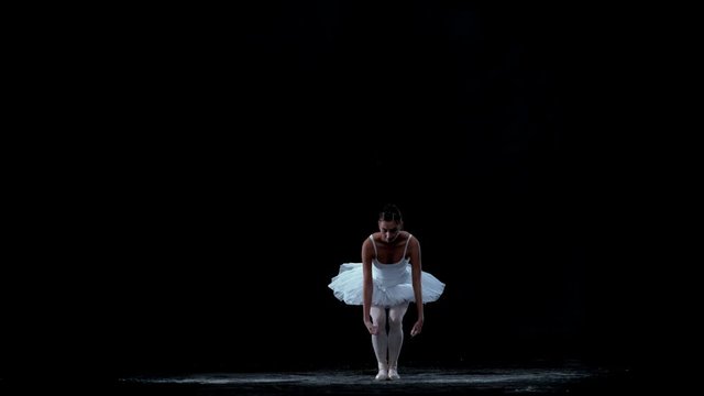 Ballerina performing on black background spinning slow motion