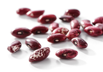 Red speckled kidney bean close-up  scattered on white background 
