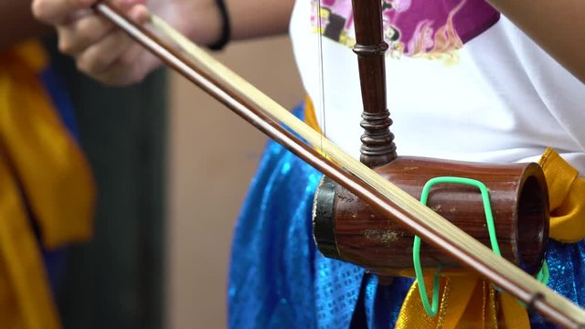 Thai children are playing Thai musical instruments, string instruments are Thai national instruments. Violin, but with less lines. The low tone is a great instrument.