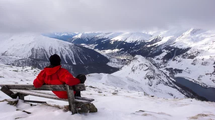 Gardinen backcountry skier takes a break and sit on a summit bench and enjoys the view of Davos in winter © makasana photo