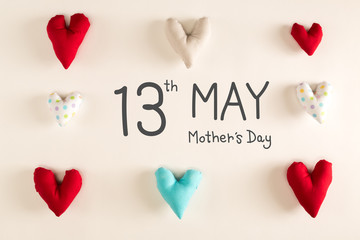 Mother's Day message with blue heart cushions on a white paper background