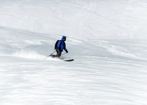 male backcountry skier telemark skiing in the Alps in fresh powder