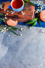 Teatime concept with homemade pastry and spring gypsophila flowers. Oatmeal cookies with wooden boxes on a concrete background with copy space.