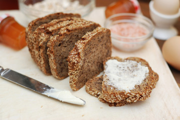 Fototapeta na wymiar Healthy Food. Rustic Whole Grain Bread with Seeds and butter. Healthy and Diet concept. Isolated. Wooden Background.