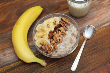 Top view of a Granola Bowl, Muesli with Oats, Nuts and Dried Fruit on Wooden table. Bannana, nuts, fruits. Healthy Breakfast. Diet.