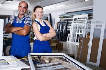 Portrait of two smiling professional workers in assembly shop