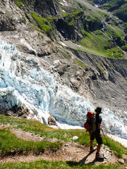 Fototapeta premium male hiker looking at a receding glacier near Grindelwald in the Swiss Alps
