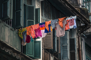 Laundry hanging outside of Old colonial window wooden architecture in Yangon Myanmar Burma South...