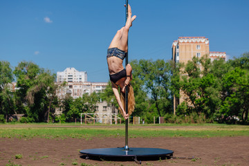 Fit attractive girl dancing near portable pole at summer day © Smile