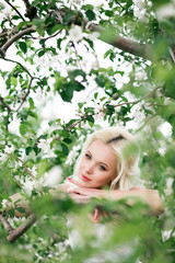 Amazing blonde bride in blooming apple garden