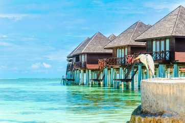 Heron and huts on the water, Maldives