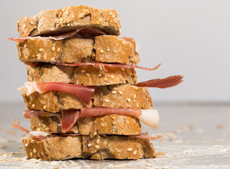 tiered sandwich made with with rye bread and ham