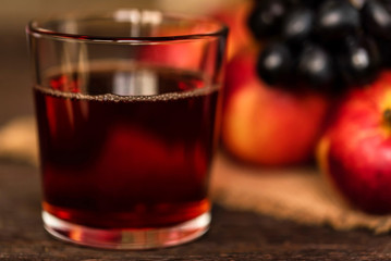 Red grape juice in glass, grapes and red apples
