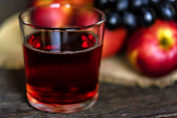 Red grape juice in glass, grapes and red apples