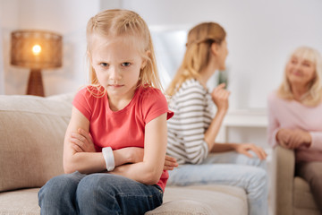 Bad mood. Nice unhappy angry girl turning away from her mother and looking at you while feeling upset