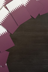 Qatar small flags framing a wood texture background with copy space