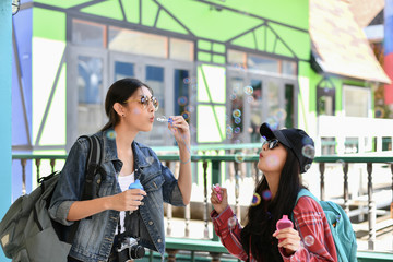 Travel Concepts. Beautiful girl is playing soap bubble fun. Asian girls are relaxing travels. Asian girls blowing bubbles into the air. Beautiful girl takes a break in playing bubble activities.