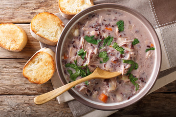 Delicious dietary soup made from wild rice with chicken and vegetables close-up. horizontal top view
