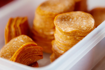 Pepperoni sausage cut into pieces lies in a plastic dish.