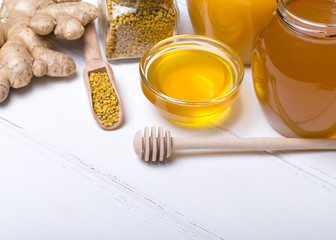 Honey with wooden honey dipper on wooden table
