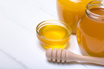 Honey with wooden honey dipper on wooden table