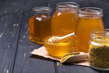 Honey with wooden honey dipper on wooden table