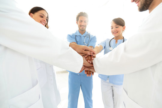 Doctors and nurses in a medical team stacking hands