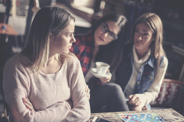 Fototapeta premium Girls playing board game at home and having serious conversation. Close up.