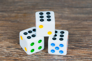 white dices with colorful dots on wooden table