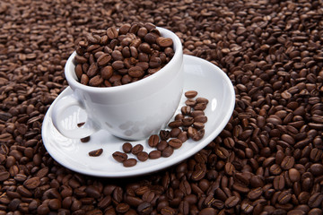 white cup of coffee at coffee beans backgrounds