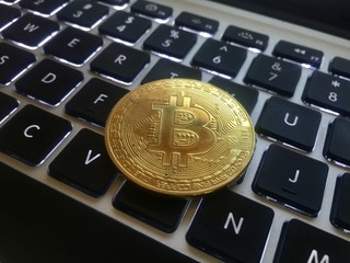 Closeup of a gold coin bitcoin coin. Selective focus and crop fragment.