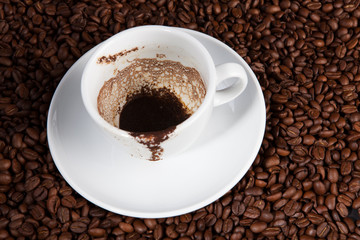 white cup of coffee at coffee beans backgrounds