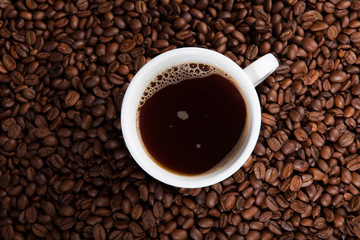 white cup of coffee at coffee beans backgrounds