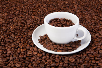 white cup of coffee at coffee beans backgrounds