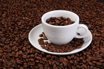white cup of coffee at coffee beans backgrounds