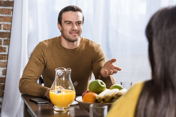 selective focus of couple talking during breakfast at home