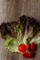 the concept of proper nutrition: dried fruits, green calad, dry apricot lie on a wooden table