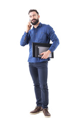 Friendly relaxed successful happy business man talking on the phone winking and looking up. Full body isolated on white background. 