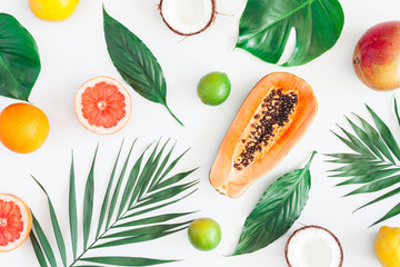 Summer tropical composition. Green palm leaves and tropical fruits on gray background. Summer...