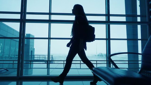 Silhouette of girl walking on airport terminal